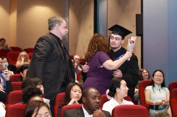 Lucas hugs his family at the graduation ceremony